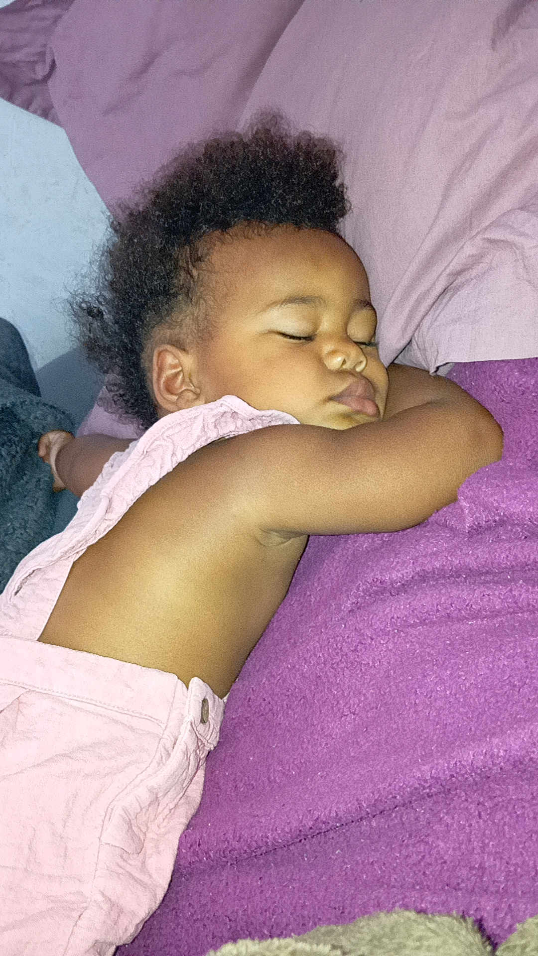 Alyah participe au concours pour gagner de l'argent avec cette photo : toddler, sleeping, child, blanket, purple, curly_hair, peaceful, nap, soft_lighting, indoor, close_up, skin, clothing, relaxing, cute, portrait, infant, resting, baby, cozy