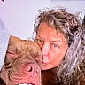 woman, piglet, animal, pet, kiss, portrait, close_up, face, curly_hair, blanket, cozy, indoor, home, cuddling, pink, wrinkles, snout, eyes, affection, selfie