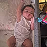 Levi is registered to the contest to win money with this photo: baby, infant, sleeping, bassinet, crib, blanket, onesie, diaper, face, portrait, indoors, nursery, furniture, soft_lighting, resting, lying_down, raised_arm, toy, fan, cozy