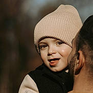Egidio participe au concours pour gagner de l'argent avec cette photo : affection, beanie, candid, child, close_up, face, hat, headwear, holding, jacket, outdoor, parent, parent_and_child, person, portrait, smile, toddler, tongue, warmth, winter_clothes