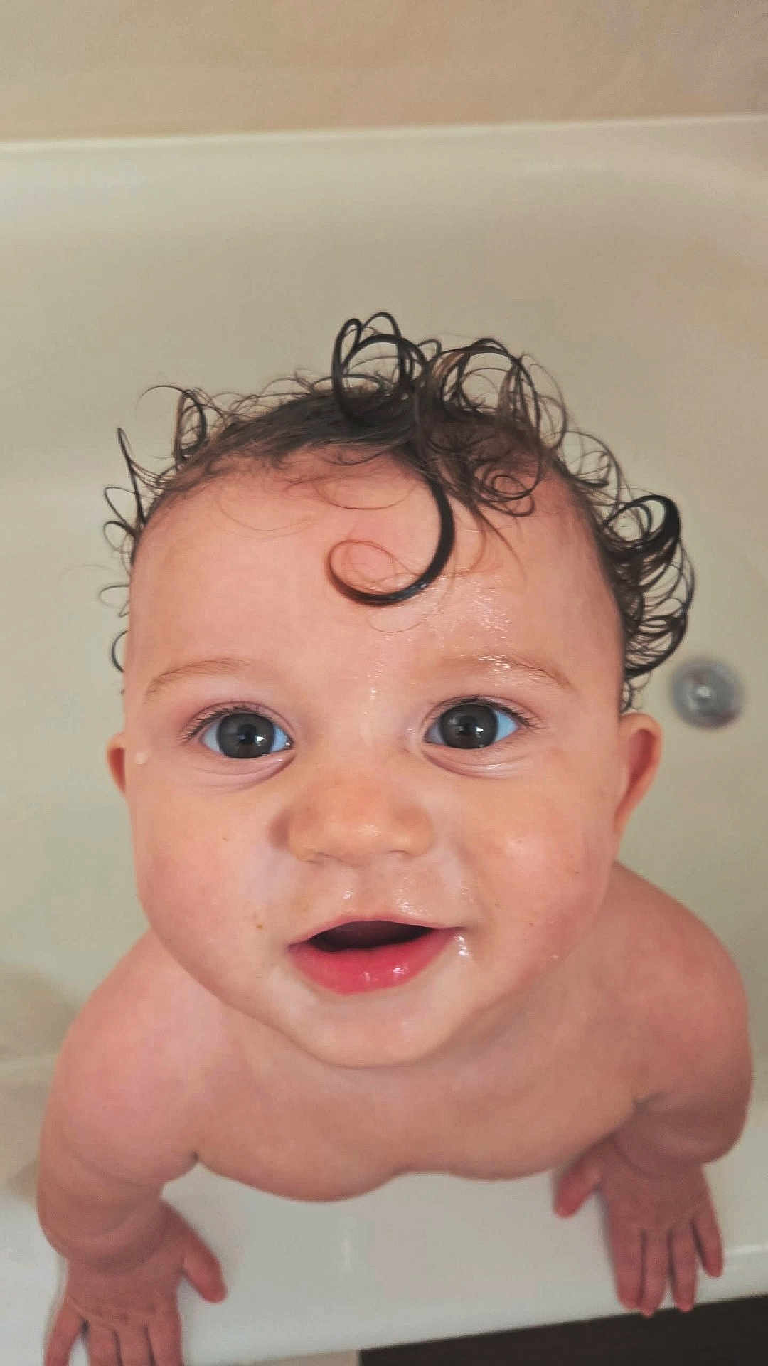 Elijah is registered to the contest to win money with this photo: baby, child, wet_hair, curly_hair, bathtub, bath, skin, face, eyes, mouth, hands, cute, innocence, water_droplets, close_up, portrait, smiling, young, person, indoor