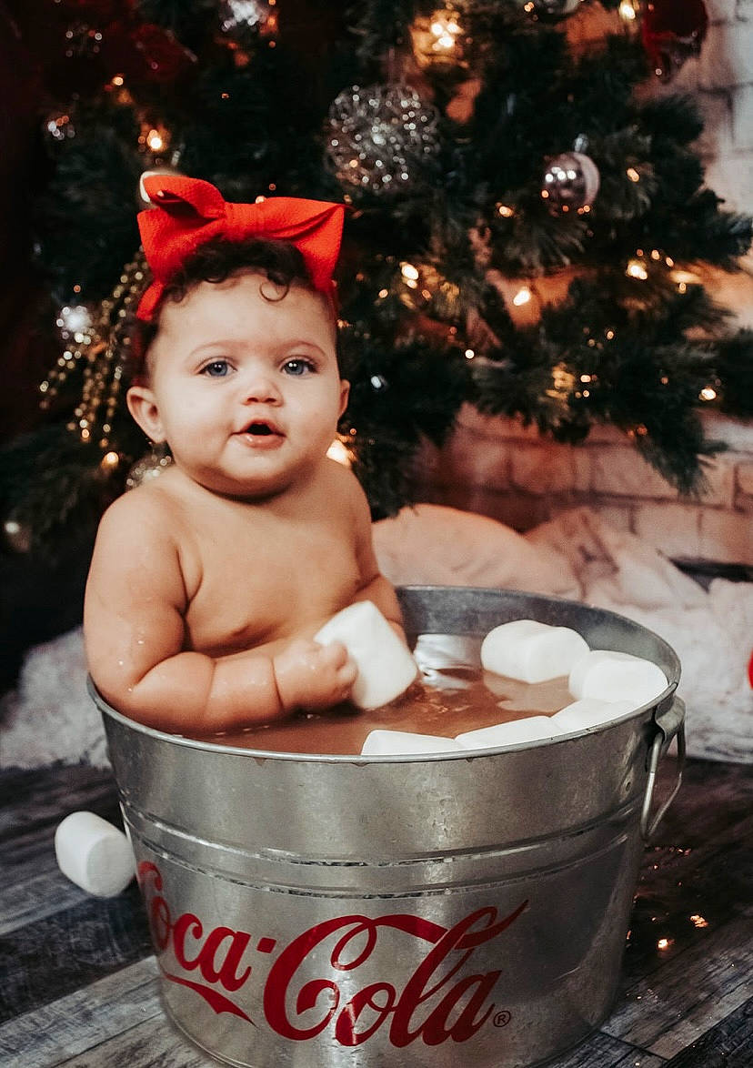 Blakeley is registered to the contest to win money with this photo: baby, carmine, child, christmas, christmas_decoration, christmas_eve, christmas_ornament, christmas_tree, conifer, cup, event, fictional_character, fir, happy, holiday, holiday_ornament, interior_design, ornament, person, serveware