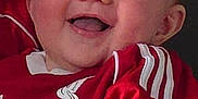 Leo-John is registered to the contest to win money with this photo: baby, child, smiling, red_jersey, liverpool_fc, football_shirt, happy, face, blue_eyes, arm, person, cute, infant, portrait, clothing, indoor, holding, skin, expression, sportswear