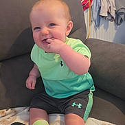 Leo-John is registered to the contest to win money with this photo: baby, child, smiling, sitting, couch, blanket, clothing, footwear, sock, face, happy, indoor, furniture, person, toddler, home, casual, green, shorts, shirt