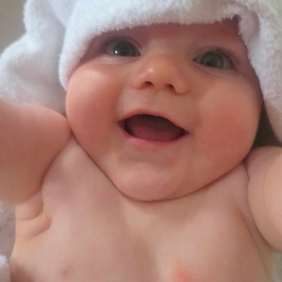 Leo-John is registered to the contest to win money with this photo: arms, baby, bare_chest, cheeks, child, closeup, cute, expression, face, happy, headwear, indoors, infant, joy, person, portrait, skin, smile, towel, young