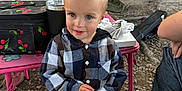 Jaxon joined the competition — help win amazing prizes! toddler, child, boy, plaid_shirt, jeans, sneakers, mohawk, blue_eyes, smile, outdoor, garage, table, bag, water_bottle, grass, rocks, person, clothing, curious, casual