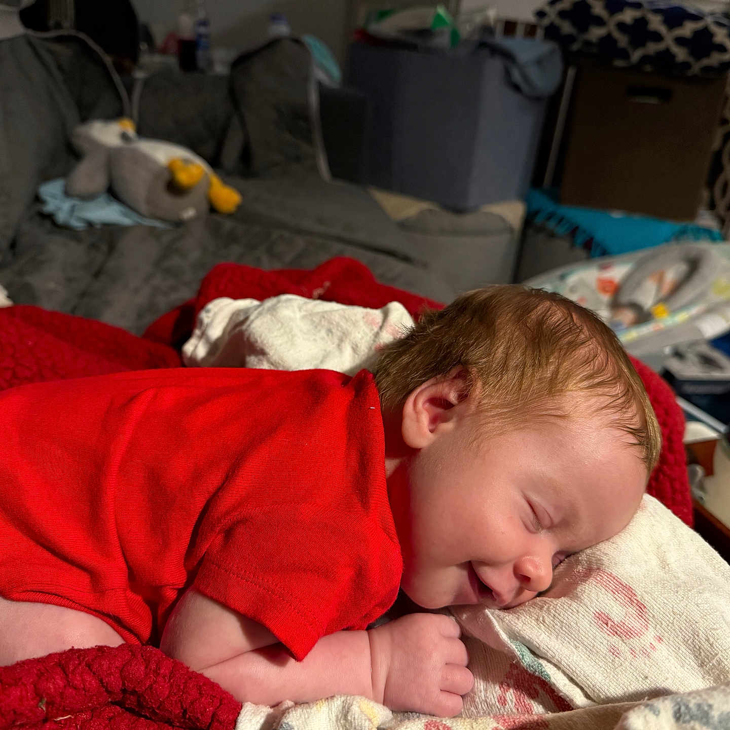 Atlas is registered to the contest to win money with this photo: baby, blanket, bottle, child, couch, cozy, cute, face, home, indoors, infant, newborn, peaceful, person, plush_toy, red_clothing, resting, sleeping, smile, soft_lighting