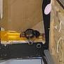 dog, indoor, blurry, resting, yellow_object, cardboard, clutter, small_dog, floor, head, tired, black, brown, white, animal, pet, quiet, furniture, object, background