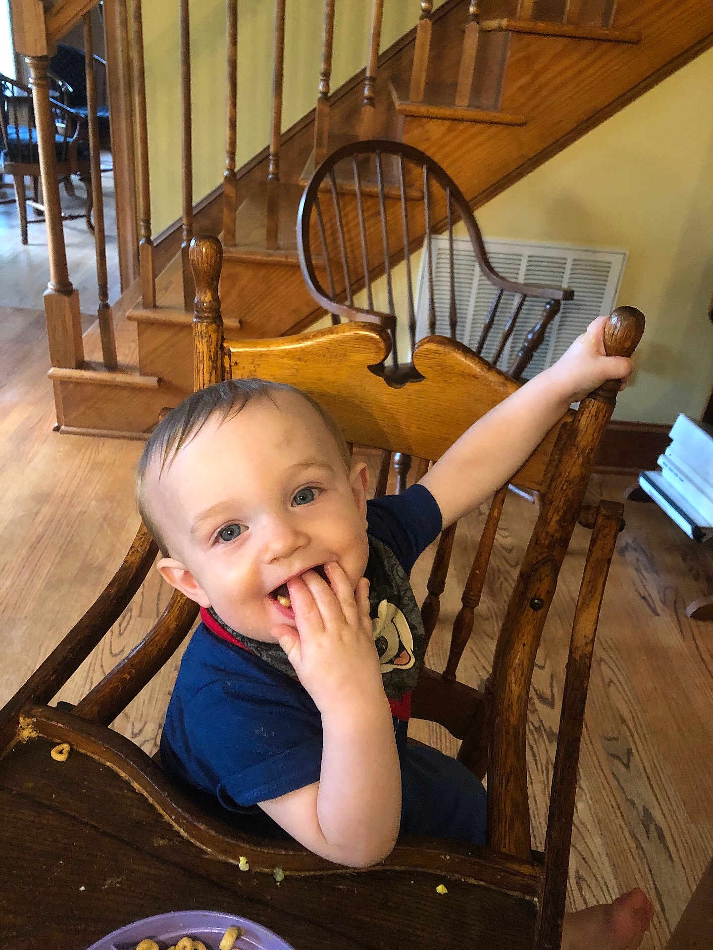 Bethany Gerstenmier is registered to the contest to win money with this photo: toddler, child, high_chair, wooden_chair, cereal, food, smile, happy, indoor, home, stairs, wood_floor, table, plate, person, face, hand, blue_shirt, cute, baby