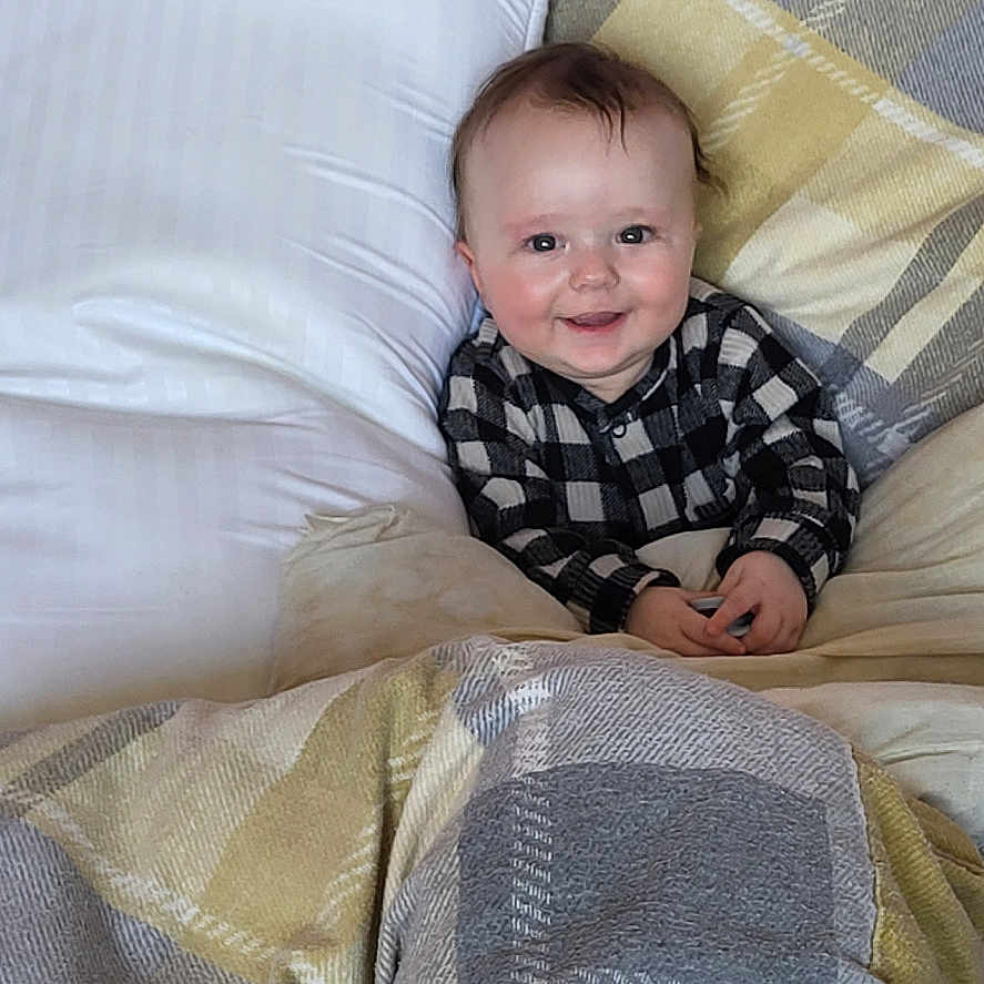 Noah joined the competition — help win amazing prizes! baby, bed, bedroom, blanket, clothing, couch, cushion, face, furniture, head, homedecor, indoors, linen, pants, person, photography, pillow, portrait, quilt, room