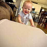 Lincoln is registered to the contest to win money with this photo: toddler, child, smiling, indoor, kitchen, furniture, table, light, happy, person, short_hair, blond, casual_clothing, wood_floor, cabinet, chair, modern, home, cute, portrait