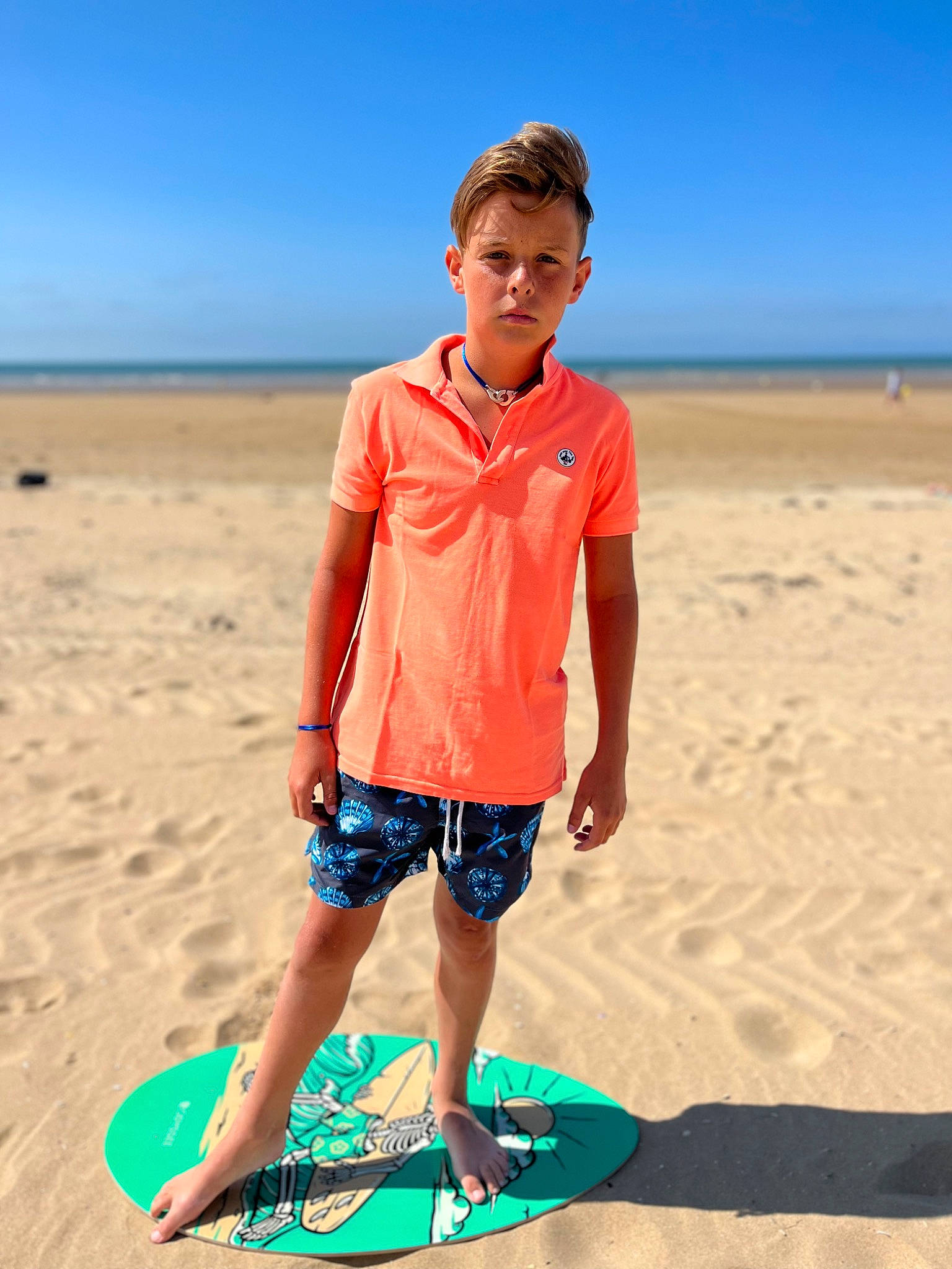 Jaden a rejoint le concours — aidez-le/la à gagner de superbes lots ! azure, beach, board_short, body_of_water, fun, happy, leisure, people_in_nature, people_on_beach, person, photograph, sand, shore, shorts, sky, sleeve, summer, surfboard, t_shirt, travel