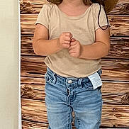 Théa a rejoint le concours — aidez-le/la à gagner de superbes lots ! beige_shirt, boots, casual_clothing, child, clothing_tag, cowboy_hat, cute, floor, flower, happy, hat, indoor, jeans, person, playful, portrait, smiling, standing, toddler, wooden_backdrop