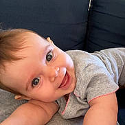 Amalya participe au concours pour gagner de l'argent avec cette photo : baby, smiling, face, eyes, arm, hand, blanket, couch, indoors, clothing, happy, infant, person, skin, cheerful, cute, baby_girl, baby_boy, lying_down, playful