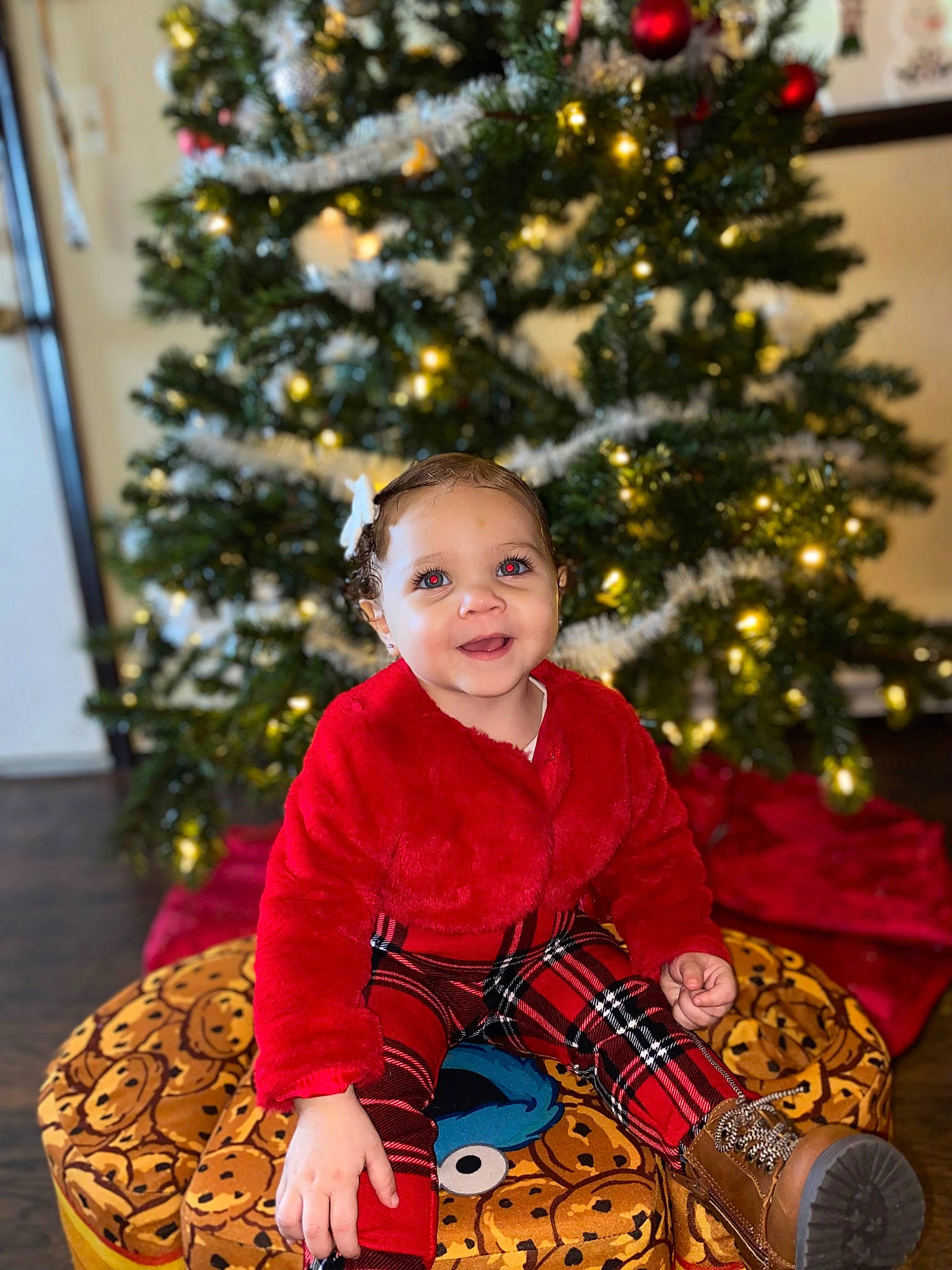 Jordyn joined the competition — help win amazing prizes! baby_toddler_clothing, christmas, christmas_decoration, christmas_eve, christmas_ornament, christmas_tree, conifer, event, happy, holiday, holiday_ornament, joy, ornament, person, plant, sitting, smile, toddler, tradition, tree