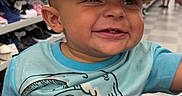 Joziyah is registered to the contest to win money with this photo: baby, blue_shirt, cartoon, child, close_up, fedora, happy, hat, indoor, infant, mickey_mouse, portrait, retail, seated, shelves, shoe_store, shoes, shopping, smiling, straw_hat