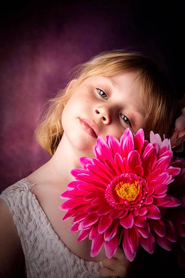 Jade participe au concours pour gagner de l'argent avec cette photo : annual_plant, blond, brown_hair, child, close_up, cut_flowers, daisy_family, eyelash, flash_photography, flower, flowering_plant, happy, iris, lip, magenta, person, petal, pink, plant, purple
