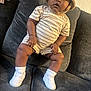Jariya is registered to the contest to win money with this photo: baby, bucket_hat, child, clothing, couch, curious, cute, furniture, hat, indoor, infant, looking, person, portrait, seated, sneakers, socks, sofa, soft_light, striped_clothes