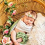 Brooke is registered to the contest to win money with this photo: baby, sleeping, basket, blanket, flower_crown, pink_flowers, green_leaves, cushion, woven_basket, infant, peaceful, soft_texture, headband, newborn, cozy, resting, indoors, portrait, cute, wrapped