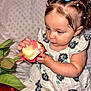 Athena is registered to the contest to win money with this photo: toddler, child, flower, rose, curious, blue_bows, dress, patterned_clothing, baby, indoor, closeup, portrait, hands, face, soft_background, cute, young_child, exploring, sitting, skin