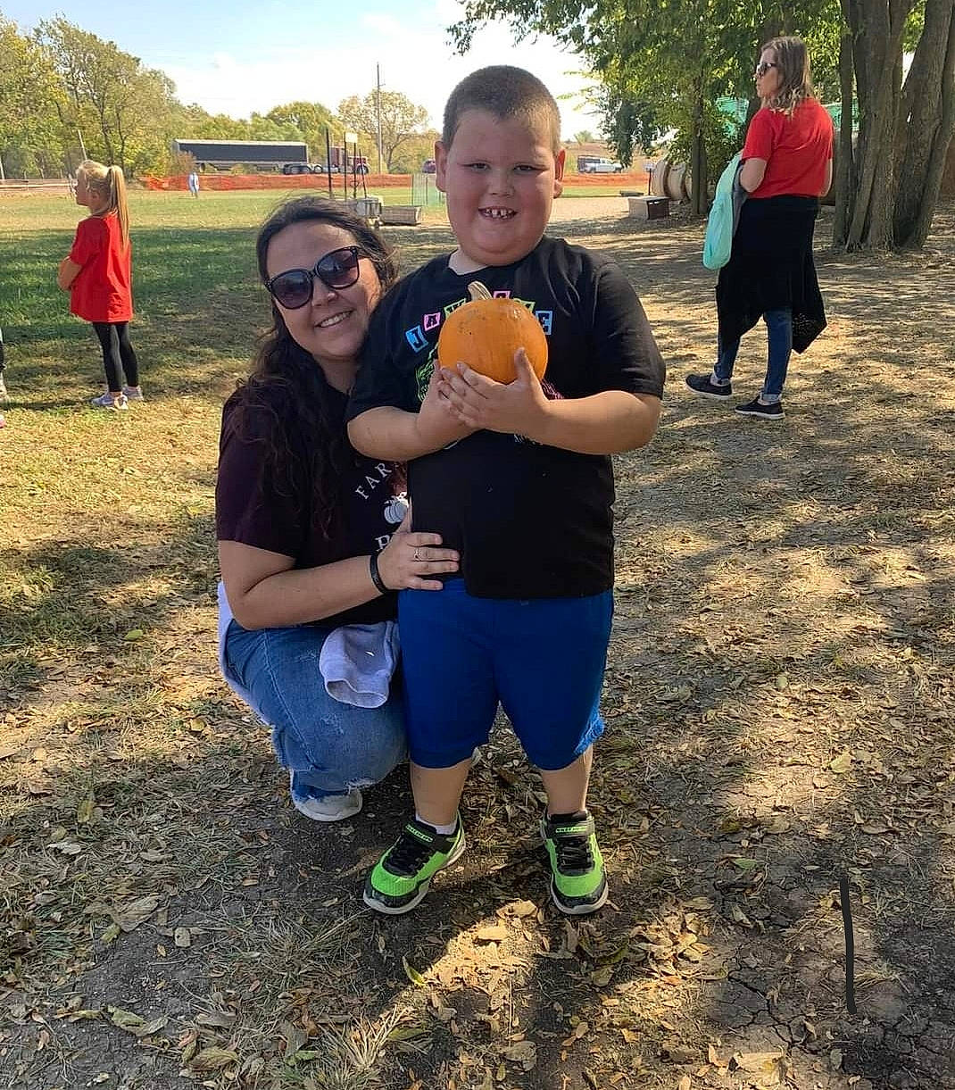 Aiden is registered to the contest to win money with this photo: event, eyewear, footwear, friendship, fun, grass, happy, joy, landscape, leg, leisure, people_in_nature, person, plant, recreation, shoe, shorts, sky, smile, sneakers