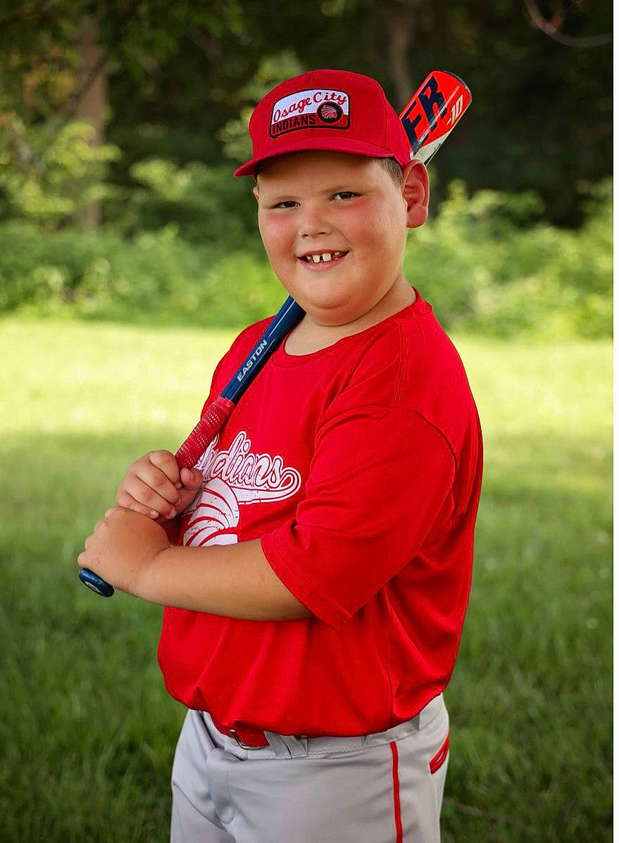 Aiden is registered to the contest to win money with this photo: baseball_cap, cap, chin, clothing, cricket_cap, elbow, electric_blue, eye, face, fun, grass, happy, headwear, human_body, joy, leisure, people_in_nature, person, player, recreation