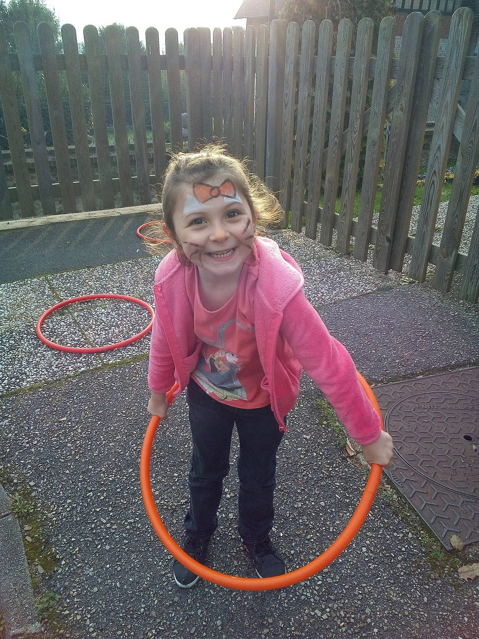 Lisa participe au concours pour gagner de l'argent avec cette photo : asphalt, balance, child, entertainment, event, fence, fun, grass, happy, home_fencing, hose, hula_hoop, joy, magenta, person, recreation, rope, sky, smile, sweatpant