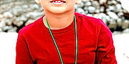 Cruz joined the competition — help win amazing prizes! child, boy, red_shirt, necklace, outdoor, portrait, smiling, young, casual_clothing, hands, face, short_hair, nature, rocks, background_blur, standing, person, daylight, skin, expression