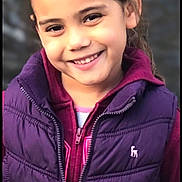 Karissa is registered to the contest to win money with this photo: child, girl, smile, face, vest, hoodie, purple, maroon, outdoor, portrait, happy, young, clothing, casual, person, jacket, zipper, closeup, warm, friendly