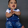 Bryan is registered to the contest to win money with this photo: baby, background, barefoot, casual_clothing, child, clapping, cute, denim_overalls, expression, feet, hands, happy, indoor, infant, portrait, short_sleeve, sitting, smiling, studio, young_child