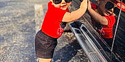 Bryan joined the competition — help win amazing prizes! toddler, child, sunglasses, red_shirt, black_shorts, cap, reflection, car, outdoor, parking_lot, playful, sunny, footwear, sidewalk, shadow, person, cute, smiling, fashion, summer