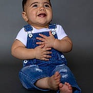 Bryan joined the competition — help win amazing prizes! baby, barefoot, casual_wear, child, cute, dark_background, denim_overalls, fashion, feet, hands, happy, isolated, portrait, sitting, smiling, spiky_hair, studio, toothy_grin, white_shirt, young_child