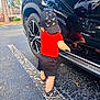 Bryan joined the competition — help win amazing prizes! toddler, child, car, black_car, reflection, cap, dinosaur_pattern, red_shirt, black_shorts, sandals, parking_lot, asphalt, palm_trees, daytime, outdoor, curious, reflection_in_car, side_view, sunny, nature