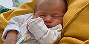 Zak is registered to the contest to win money with this photo: newborn, baby, sleeping, infant, yellow_hoodie, cozy, soft_light, indoor, person, closeup, peaceful, cute, child, resting, portrait, hand, face, clothing, window, pillow