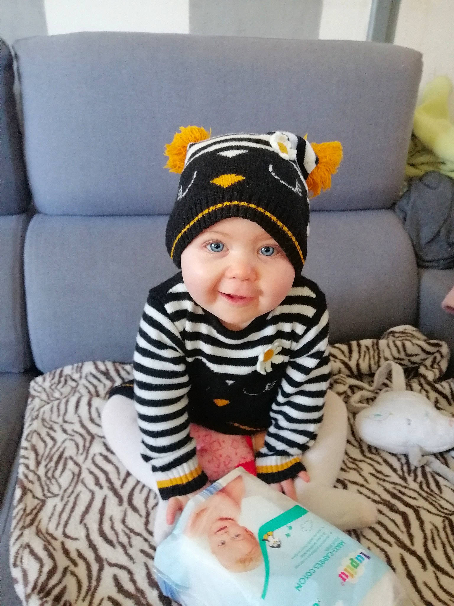 Paloma a rejoint le concours — aidez-le/la à gagner de superbes lots ! baby, baby_toddler_clothing, cap, child, comfort, costume_hat, couch, face, fashion_accessory, happy, headwear, linens, pattern, person, room, sitting, sleeve, smile, sock, t_shirt