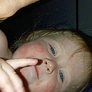 Layla is registered to the contest to win money with this photo: child, face, hand, finger, phone, blue_eyes, rosy_cheeks, blond_hair, curious, close_up, indoor, portrait, person, skin, playing, casual, technology, adult_hand, expression, candid