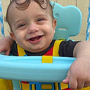 Ryder joined the competition — help win amazing prizes! baby, blue_seat, child, close_up, curly_hair, face, hands, happy, joy, outdoor, playground, portrait, red_clothing, safety_harness, shorts, smiling, swing, teeth, wooden_background, yellow_straps