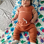 Samir Aaron Fermin is registered to the contest to win money with this photo: baby, bed, blanket, casual, child, clothing, cute, elephant_pattern, home, indoor, infant, person, pillow, portrait, relaxed, resting, sleepwear, socks, soft_lighting, young_child