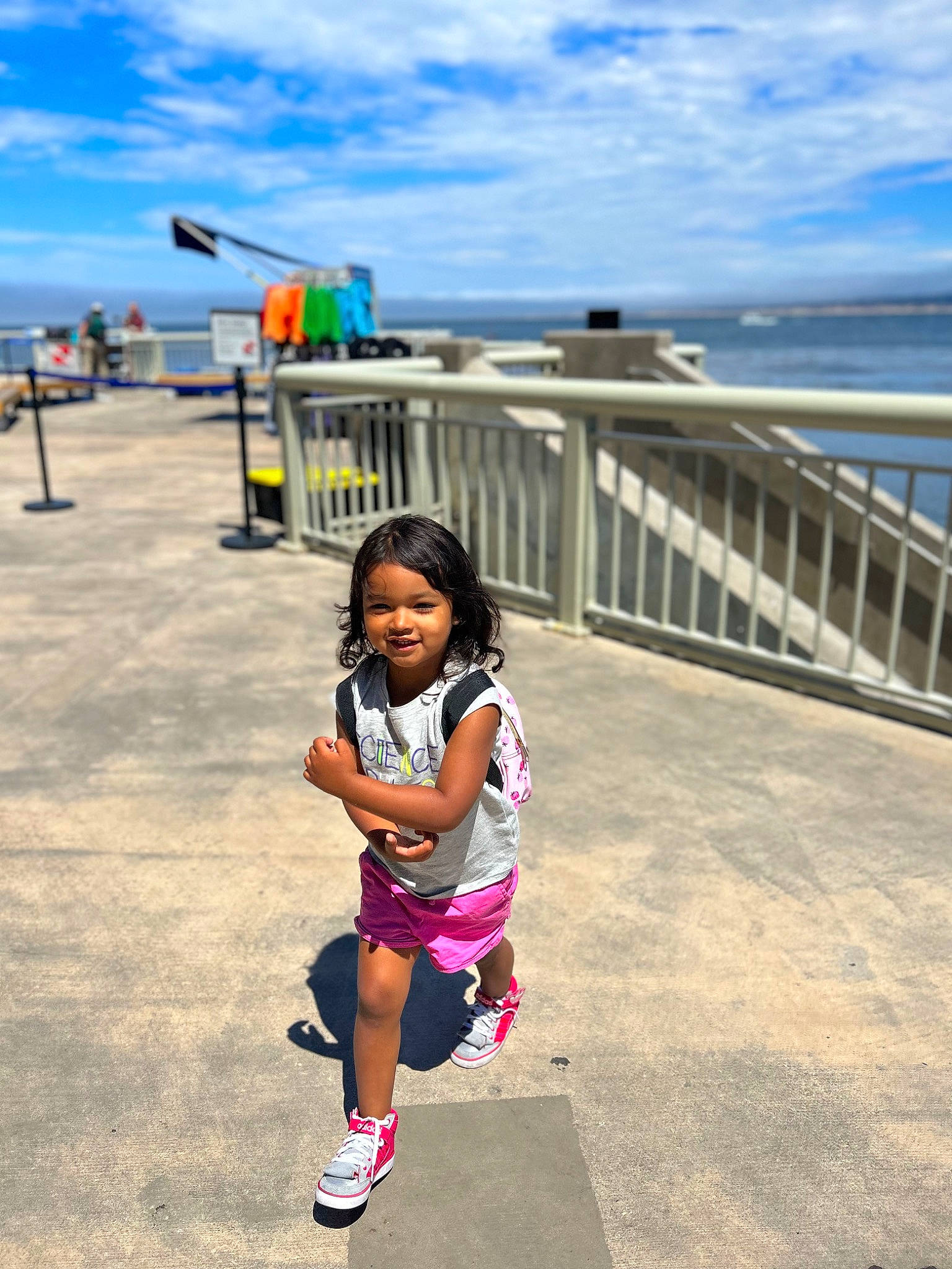 Lilah joined the competition — help win amazing prizes! boardwalk, city, cloud, coast, fence, fun, happy, horizon, joy, leisure, ocean, person, recreation, sand, shore, shorts, sky, summer, t_shirt, toddler