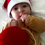 Liam participe au concours pour gagner de l'argent avec cette photo : baby, blanket, celebration, child, christmas_ornament, clothing, cozy, cute, face, festive, hand, holiday, indoor, infant, newborn, portrait, santa_hat, smiling, soft_texture, winter