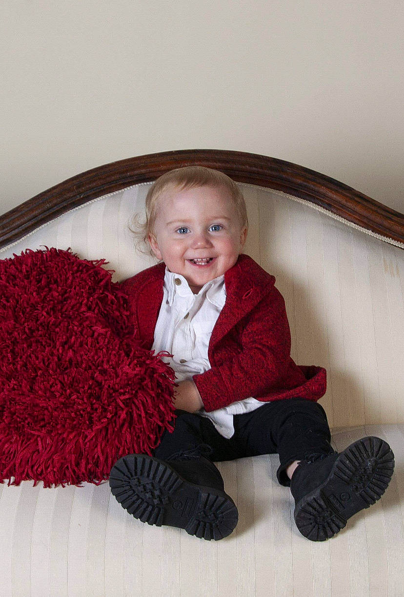 Craig is registered to the contest to win money with this photo: arm, baby, baby_toddler_clothing, cheek, clothing, comfort, eye, face, finger, flooring, human_body, joy, leg, outerwear, person, shoe, skin, sleeve, smile, sock