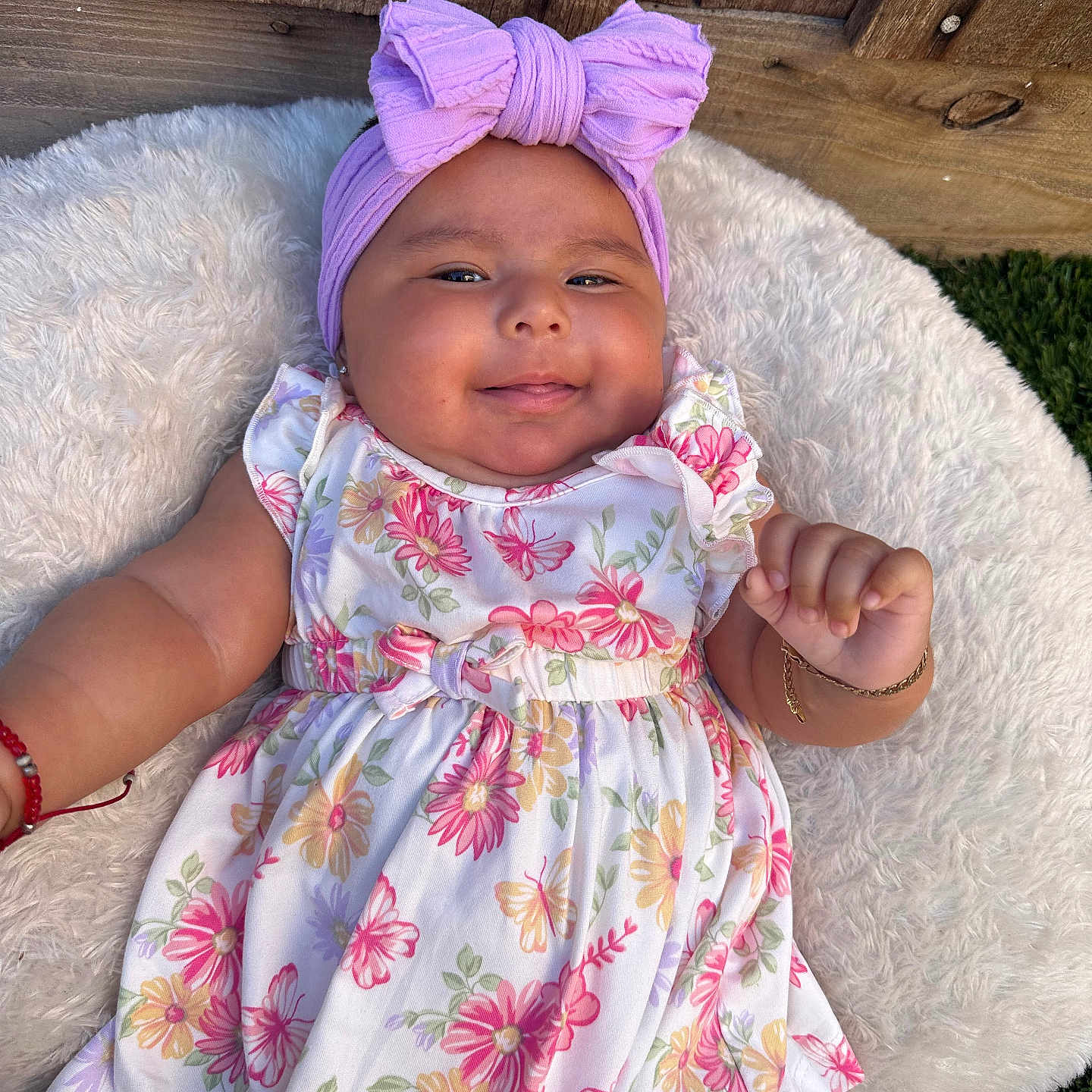 Ailaney joined the competition — help win amazing prizes! accessory, baby, bow, child, cushion, cute, fashion, floral_dress, grass, happy, headband, infant, lying_down, outdoor, person, portrait, skin, smiling, toddler, wooden_fence