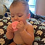 Aria is registered to the contest to win money with this photo: baby, child, pacifier, mohawk, indoor, blanket, elephant_pattern, diaper, cute, infant, person, sitting, hand, face, hair, window, curtain, room, furniture, toy