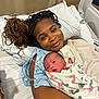Alpha joined the competition — help win amazing prizes! newborn, mother, hospital_bed, blanket, braids, smile, baby, woman, medical_tubes, hospital_gown, bed, pillow, infant, person, indoor, healthcare, love, family, rest, portrait
