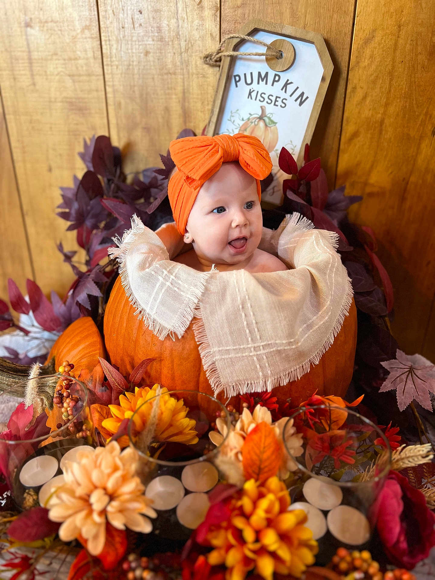 Maycel joined the competition — help win amazing prizes! baby, pumpkin, headband, orange, flower, candle, fall, autumn, decor, leaf, wooden_background, smiling, infant, table, thanksgiving, holiday, cute, portrait, indoor, festive