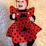 baby, child, smiling, red_bow, ladybug_outfit, black_polka_dots, headband, happy, infant, cute, costume, lying_down, soft_rug, black_clothing, toddler, cheerful, portrait, indoor, adorable, fashion