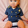 baby, child, infant, sailor_shirt, blue_eyes, flower_headband, sitting, pink_blanket, cute, portrait, clothing, gold_buttons, soft_texture, indoors, skin, person, legs, hands, head, face
