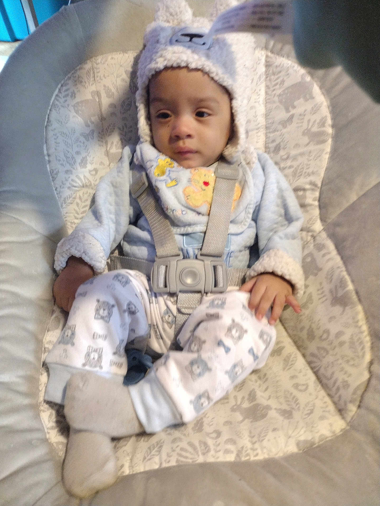 William is registered to the contest to win money with this photo: baby, child, infant, hat, pajamas, baby_seat, straps, cushion, patterned_clothing, socks, indoors, calm, cute, face, person, young_child, apparel, soft_texture, comfort, seated