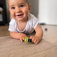 Nayim participe au concours pour gagner de l'argent avec cette photo : baby, child, toy_car, carpet, smiling, happy, indoors, face, hand, white_shirt, floor, crawling, cute, infant, playtime, bright, portrait, closeup, young_child, curious