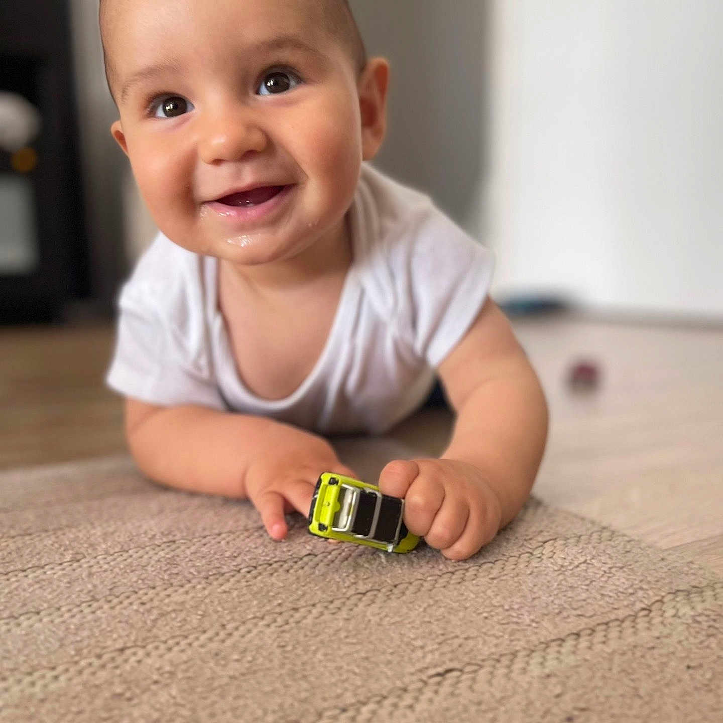 Nayim participe au concours pour gagner de l'argent avec cette photo : baby, child, toy_car, carpet, smiling, happy, indoors, face, hand, white_shirt, floor, crawling, cute, infant, playtime, bright, portrait, closeup, young_child, curious